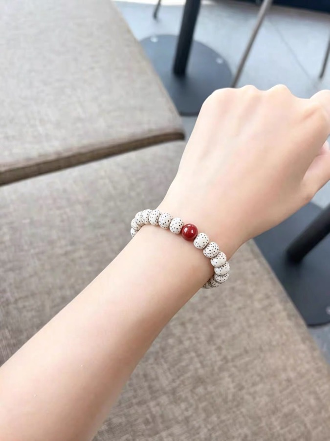 Customer-shared photo of white Bodhi beads with a red accent bead on wrist